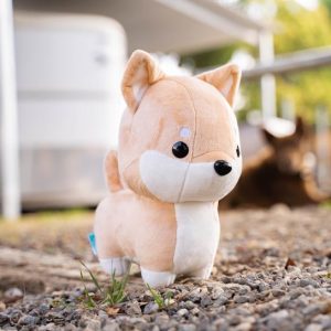 side view of shibi inu plush on gravel